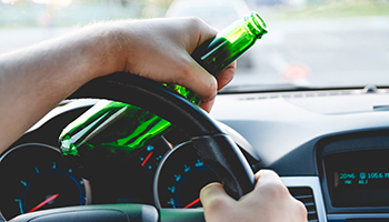 Drunk driver drinking beer while driving a car